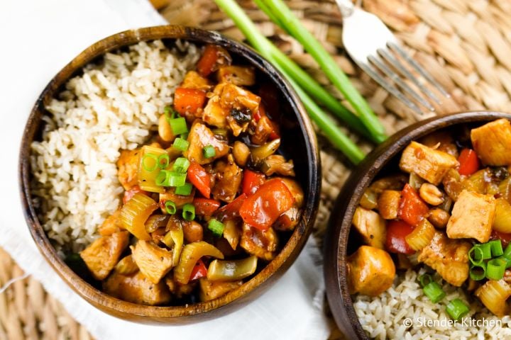 Healthy Kung Pao chicken with red peppers in a wooden bowl.