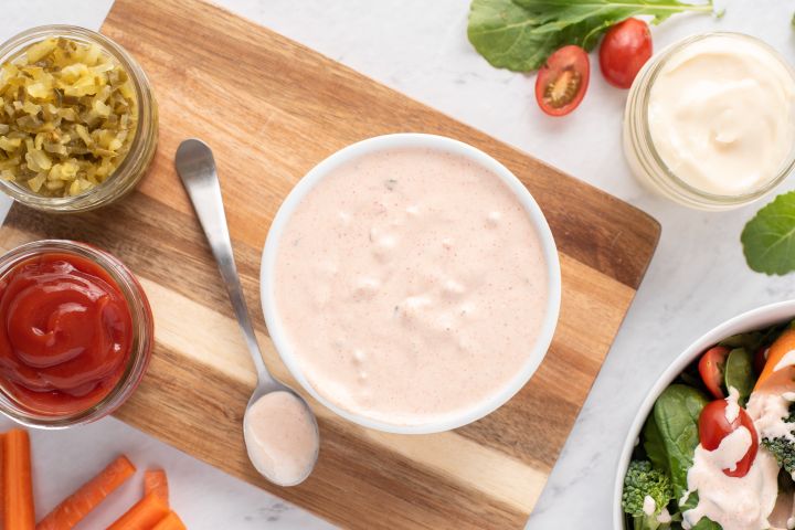 Healthy Thousand Island dressing in a bowl with ketchip, yogurt, relish, and salad on the side.