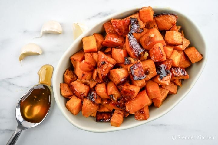 Roasted sweet potatoes with garlic cloves and a spoonful of honey.