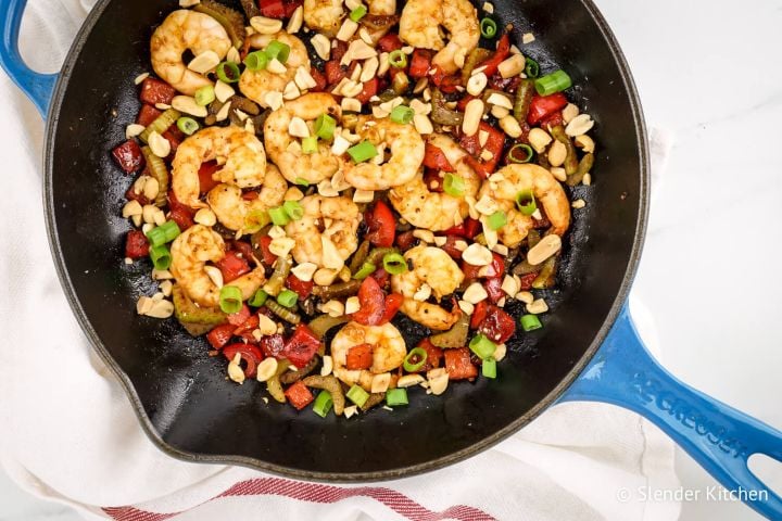 Kung Pao Shrimp with peanuts, celery, red peppers, and green onions in a skillet.