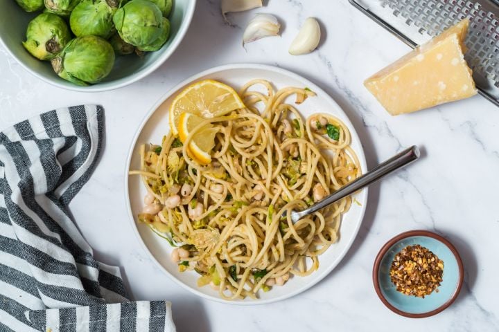 Lemon Brussels sprouts and Parmesan pasta with whole wheat spaghetti , shaved Brussels sprouts, lemon, white beans, and Parmesan cheese.