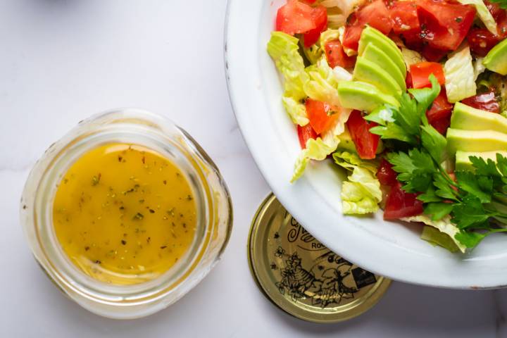 Light Italian dressing in a jar with olive oil, vinegar, and lemon and served over a green salad.