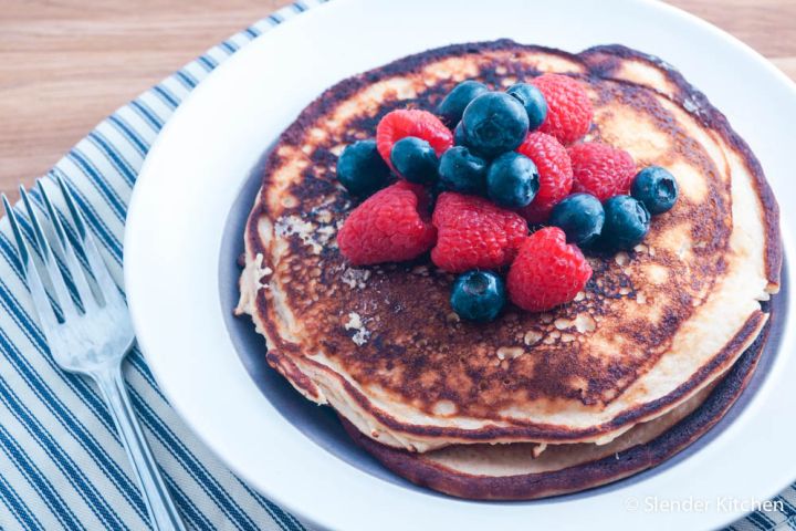 Low carb protein pancakes with cottage cheese served on a plate with berries.