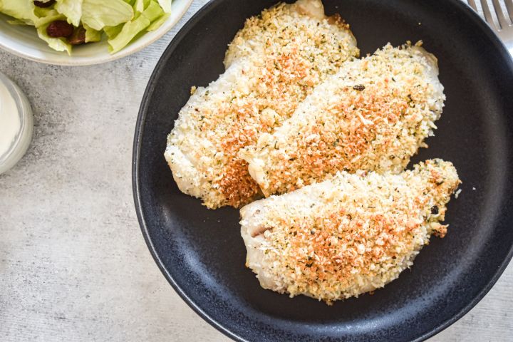 Cooked Parmesan crusted Tilapia fish on a round plate