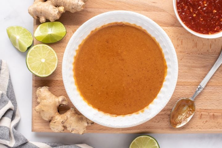 Peanut sauce made with peanut butter, soy sauce, maple syrup, ginger, hot sauce, and rice vinegar in a small bowl.