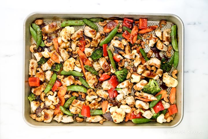 Thai Cashew Chicken with vegetables on a sheet pan.
