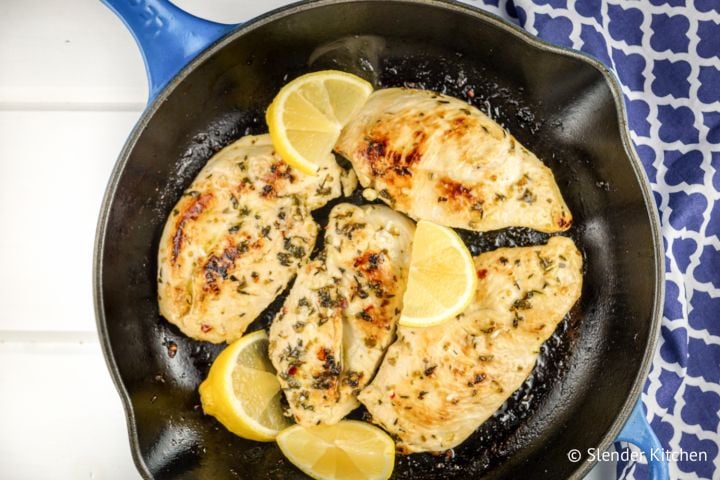 Skillet lemon oregano chicken in a cast iron skillet with parsley.