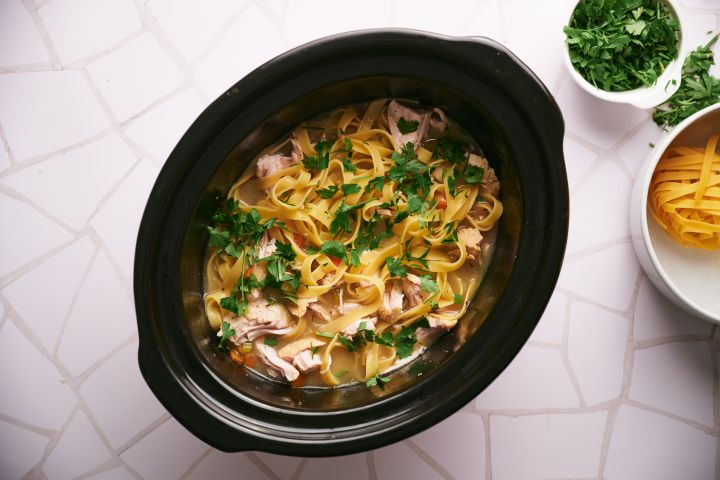 Slow cooker turkey soup with shredded turkey breast, egg noodles, carrots, celery, and onions.