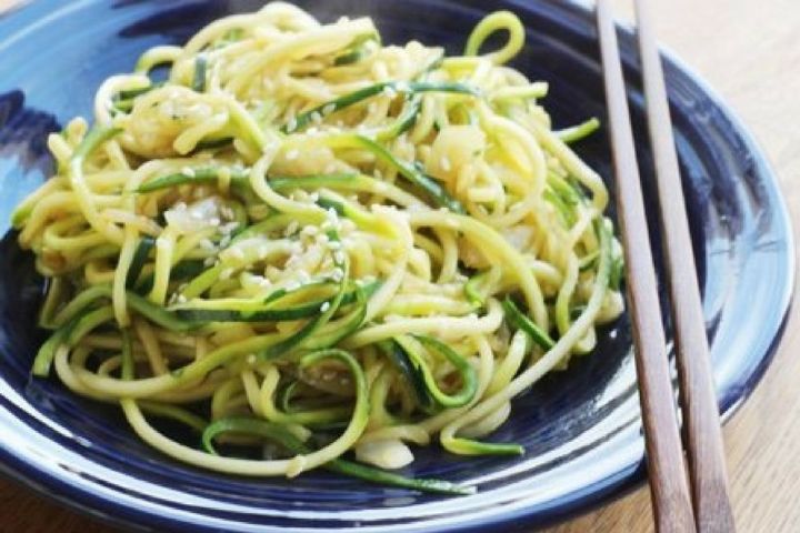 Stir Fried zucchini noodles on a plate with sesame seeds.
