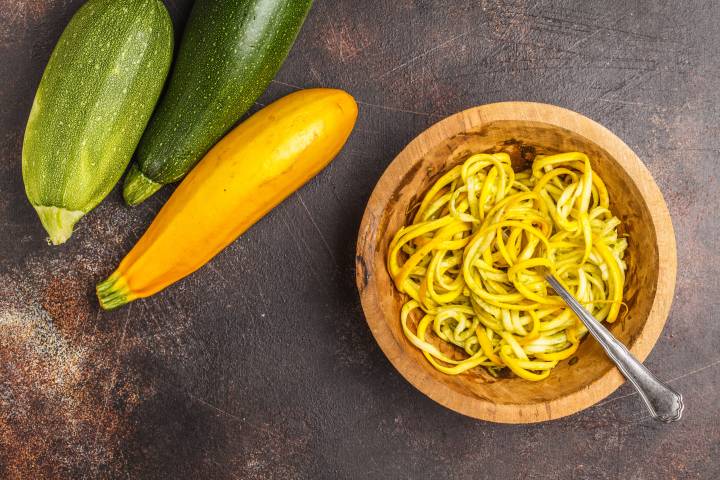 Summer squash noodles in a wooden bowl with a fork.