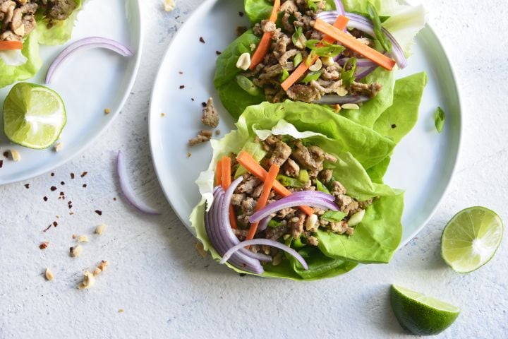 Thai turkey lettuce wraps with butter lettuce, ground turkey, carrots, cilantro, and chopped peanuts.