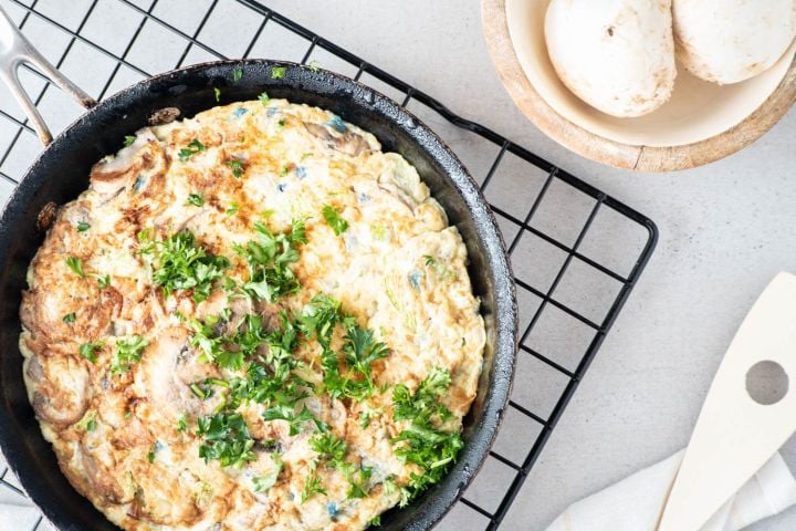 Vegetable and Hashbrown egg casserole in a cast iron skillet with fresh parsley.