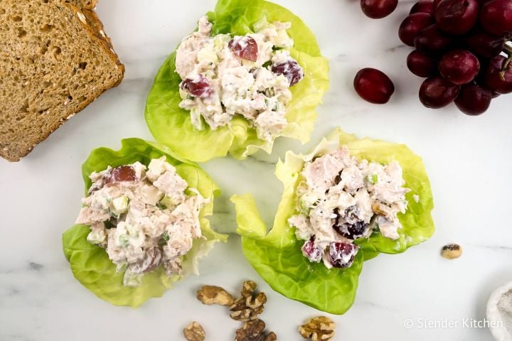 Waldorf chicken salad wrapped in lettuce with grapes, walnuts, and whole wheat bread.