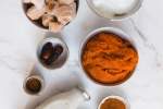 Ingredients for a pumpkin smoothie including pumpkin puree, yogurt, banana, dates, cinnamon, oats, and milk.
