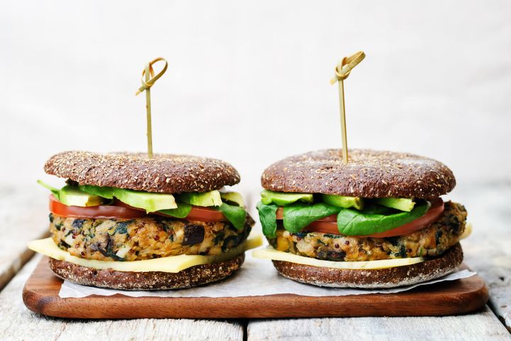 Veggie burgers with vegetables on a gluten free roll.