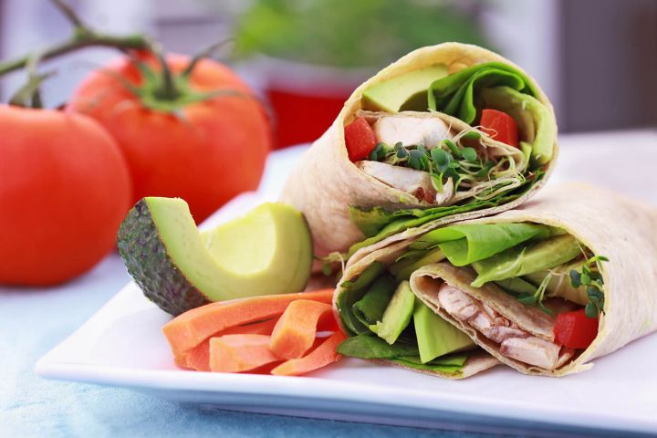 Vegetable wrap sandwiches with avocado, carrots, and lettuce.
