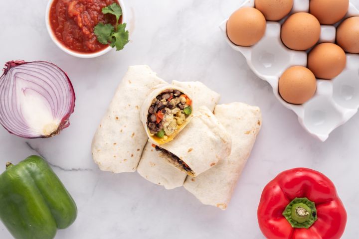 Freezer friendly breakfast burritos with eggs, black beans, peppers, salsa, and onions.