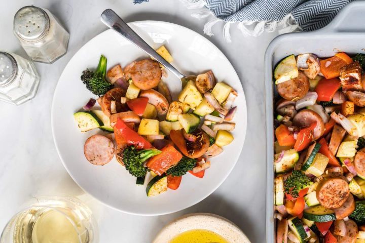 One pan chicken sausage with potatoes, broccoli, zucchini, and bell peppers on a plate.