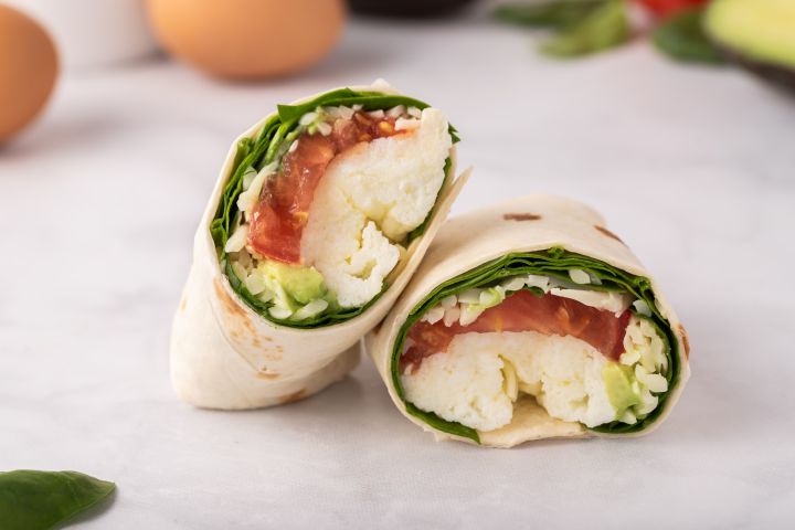 Quick egg white and avocado breakfast wrap with tomatoes and cheese.