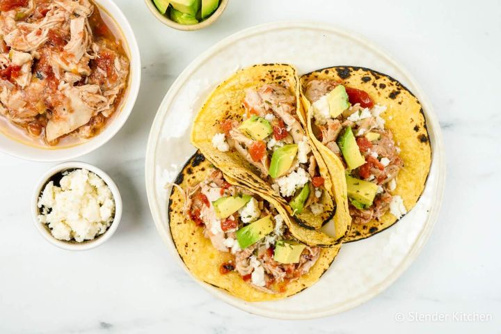 Chicken tinga served in corn tortillas with avocado and packed in a tupperare for meal prep.