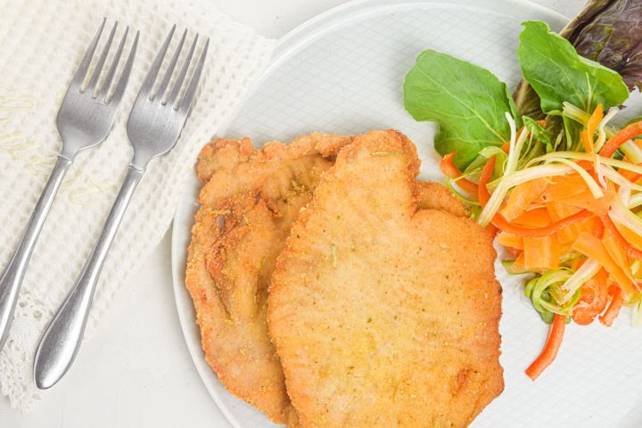 Honey mustard pork with a light breading on a plate with salad.