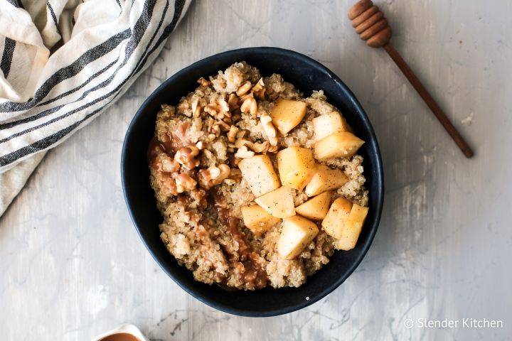 Apple cinnamon quinoa breakfast bowl with chopped apples, cinnamon, cooked, quinoa, and walnuts. 
