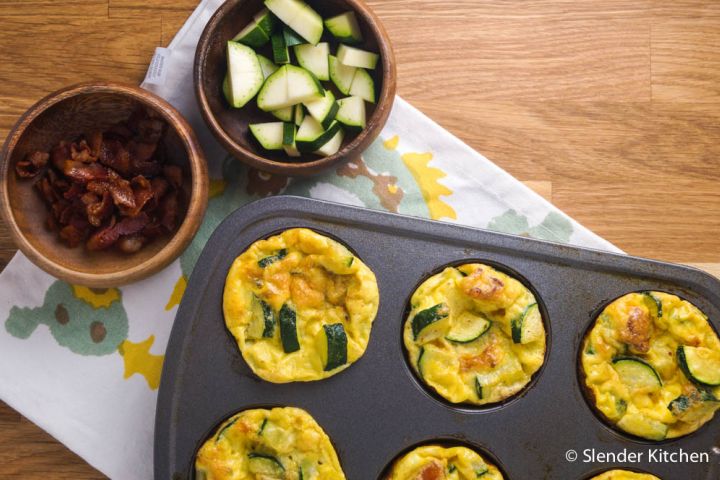 Bacon, zucchini, and cheese egg muffins in a muffin tin. 