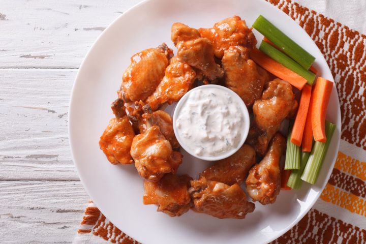 Baked buffalo wings with carrots and celery sticks and ranch dressing.