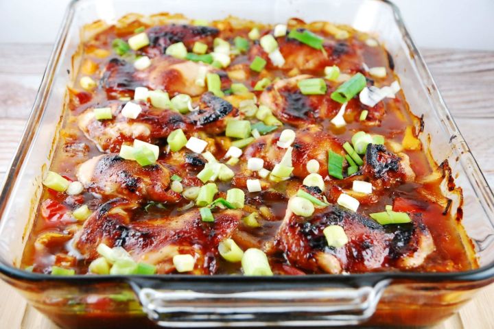 Baked teriyaki chicken in a glass baking dish with green onions on top.