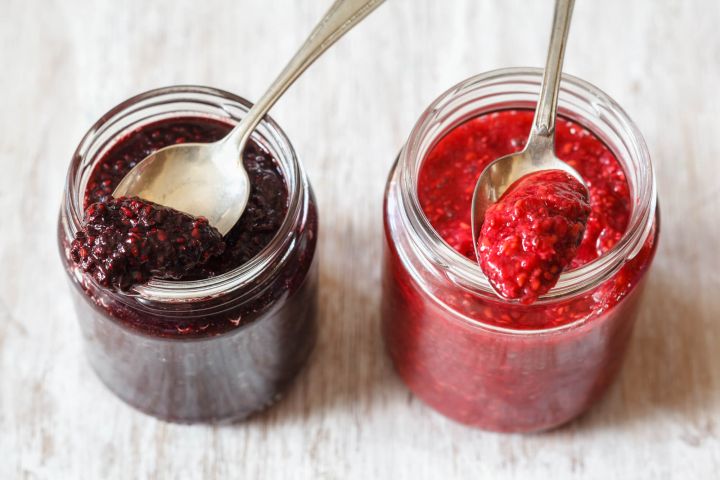 Chai seed jam with fresh berries in glass jars.