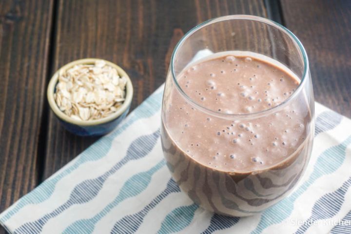 Chocolate oatmeal smoothie in a glass mason jar with a banana garnish.
