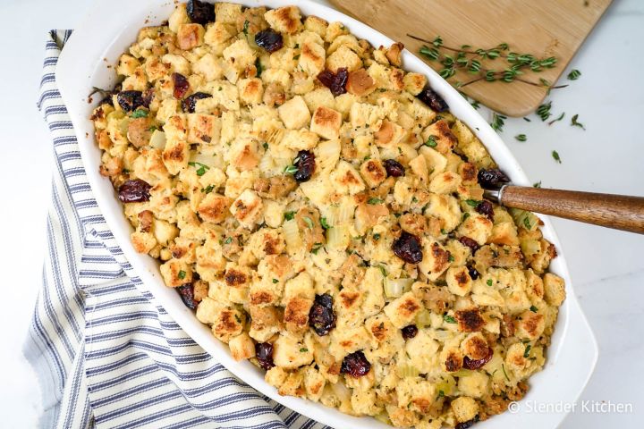 Healthy cornbread sausage stuffing with dried cranberries and thyme in a baking dish.