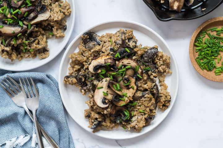 One pot creamy mushroom rice made with bella mushrooms and brown rice on a white plate. 