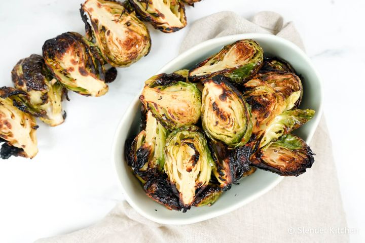 Grilled Brussel Sprouts on a skewer and in a bowl with grill marks.