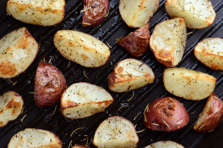 Grilled red potatoes on a grill pan with salt and pepper.