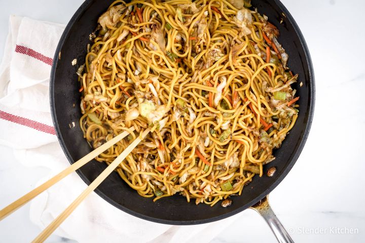 Chinese Chow mein with cabbage, noodles, and celery in soy sauce in a pan.