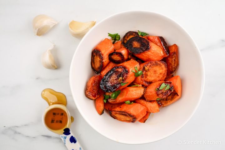 Honey garlic roasted carrots in a bowl with parsley. 