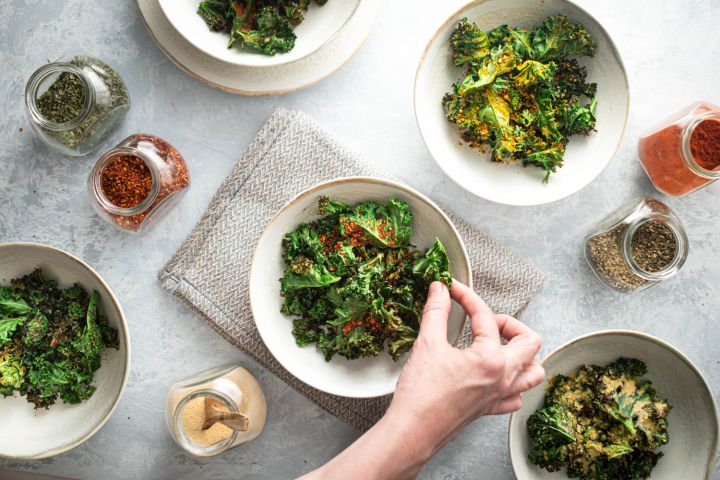 Kale chips that are baked in the oven and served in bowls with different spice blends.