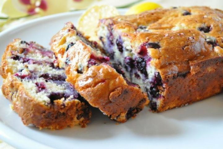 Healthy lemon blueberry bread cut into slices with blueberries and lemon zest.