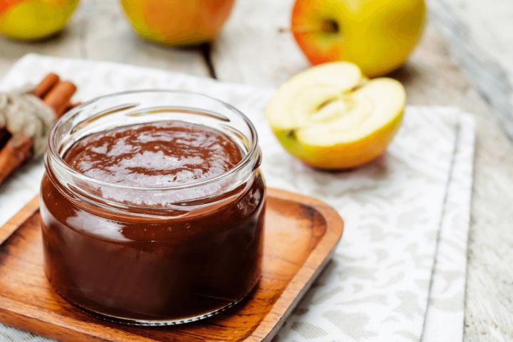 Healthy apple butter in a jar with a spoon.
