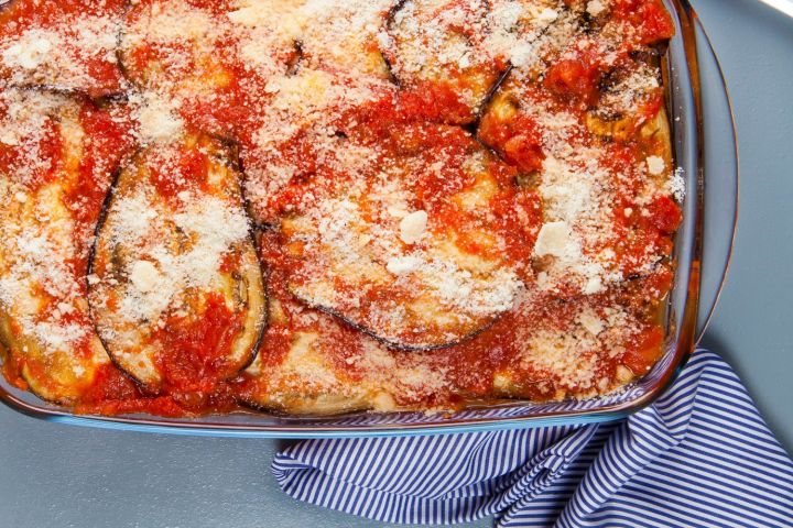 Low carb eggplant Parmesan in a glas baking dish with melted cheese and sauce.