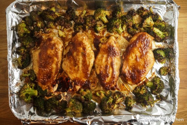 Sheet Pan peanut chicken and broccoli with peanut sauce on a baking sheet.