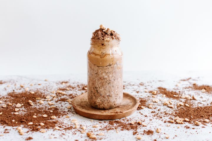 Peanut butter cup overnight oats in a glass jar with peanut butter and cocoa powder.