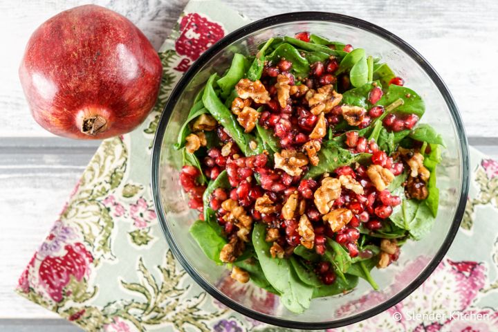Pomegranate vinaigrette served over a salad with greens, walnuts, and pomegranate arils.