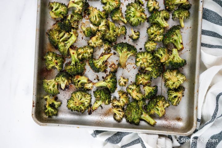 Roasted frozen broccoli on a baking sheet with seasonoing.