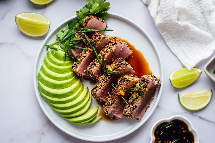 Sesame crusted tuna sliced and cooked rare served with soy dipping sauce and avocado.