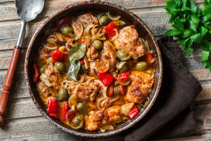 Slow Cooker Mediterranean Chicken with roasted red peppers, olives, capers, and more in a skillet.