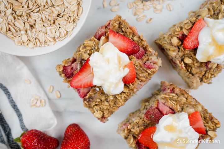 Strawberry banana baked oatmeal cut into sqaures with yogurt and honey on top.
