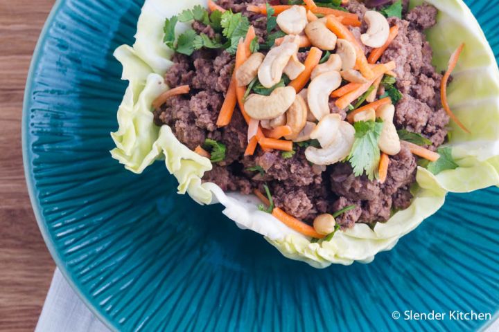 Thai beef cabbage wraps with cashews, cilantro, and carrots on a plate. 