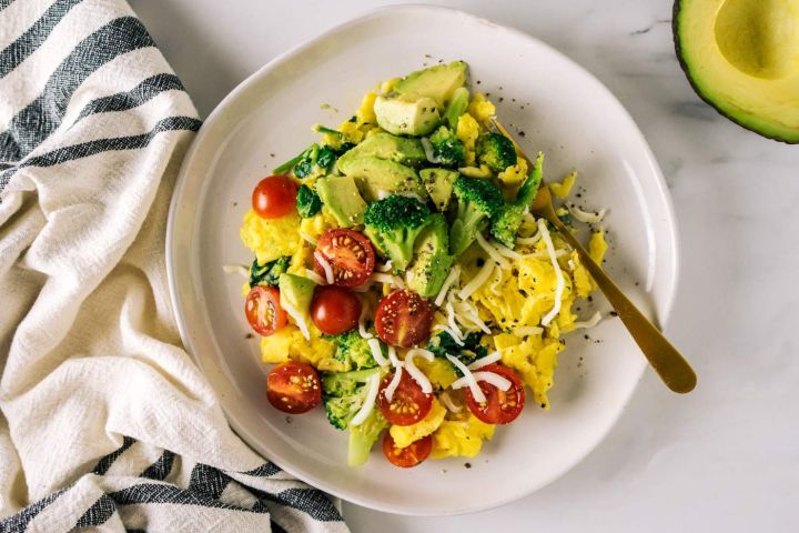 Veggie scramble with broccoli, tomatoes, onions, red pepper, and topped with avocado.